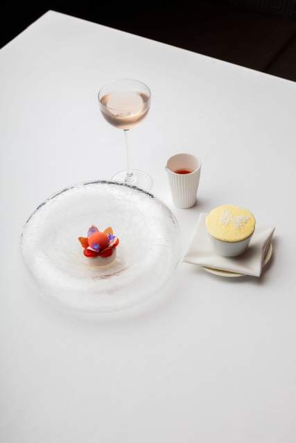 Un dessert raffiné, accompagné de ses accompagnements, présenté dans un décor épuré et minimaliste.