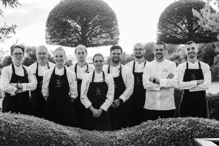 Équipe du restaurant réunie en extérieur en tenue professionnelle et conviviale.