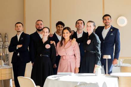 Njomza Musli posant dans la salle du restaurant avec des tables soigneusement dressées.
