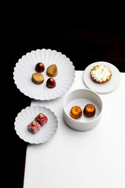 Une sélection de desserts raffinés présentés sur d'élégantes assiettes blanches.
