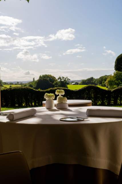 Une table de restaurant avec vue sur la campagne.
