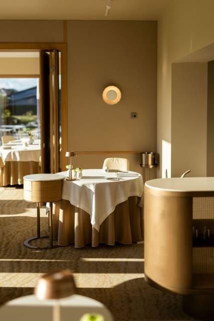 Une table de restaurant élégamment dressée dans une ambiance chaleureuse et contemporaine.